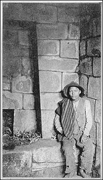 Uno de los ayudantes de Hiram Bingham junto a una de las grandes hornacinas del Mausoleo Real, en la cueva bajo del Templo del Sol. 1911